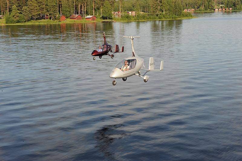 Zwei AutoGyro Calidus im Formationsflug über einem finnischen See